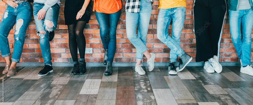 People diversity. Cropped shot of men women legs in jeans. Group standing  leaning against brick wall. Relaxed millennials Stock Photo | Adobe Stock