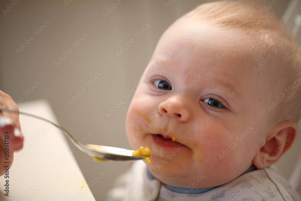 A child of 6 months pedagogical feeding from a spoon of porridge. A child of 6 months pedagogical feeding from a spoon of porridge.