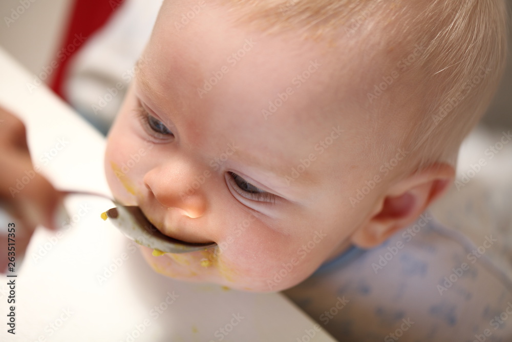 A child of 6 months pedagogical feeding from a spoon of porridge. A child of 6 months pedagogical feeding from a spoon of porridge.