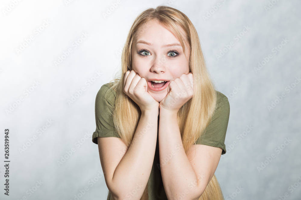 Amazed woman looks with joy and smile, being shocked to hear good news.