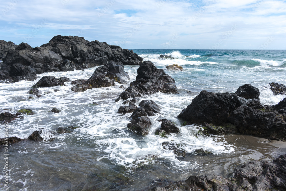 Coast rocks in azores. Waves splashing on basalt rocks