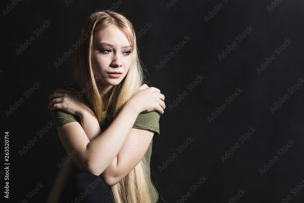 Sad young woman going to cry in a black background Sad young woman going to cry in a black background