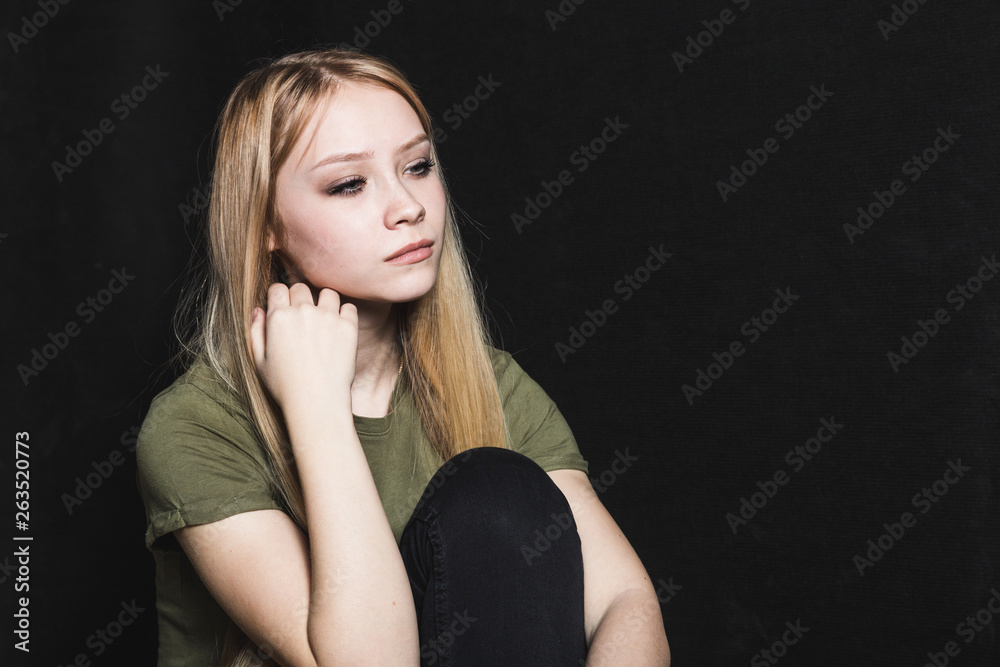 Sad young woman going to cry in a black background Sad young woman going to cry in a black background