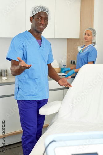 Dermatologist standing in salon of esthetic cosmetology, female on background
