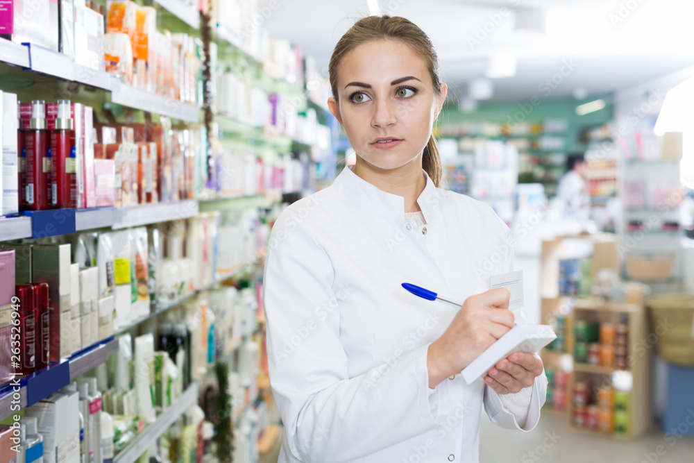 girl pharmacist is inventorying druggist
