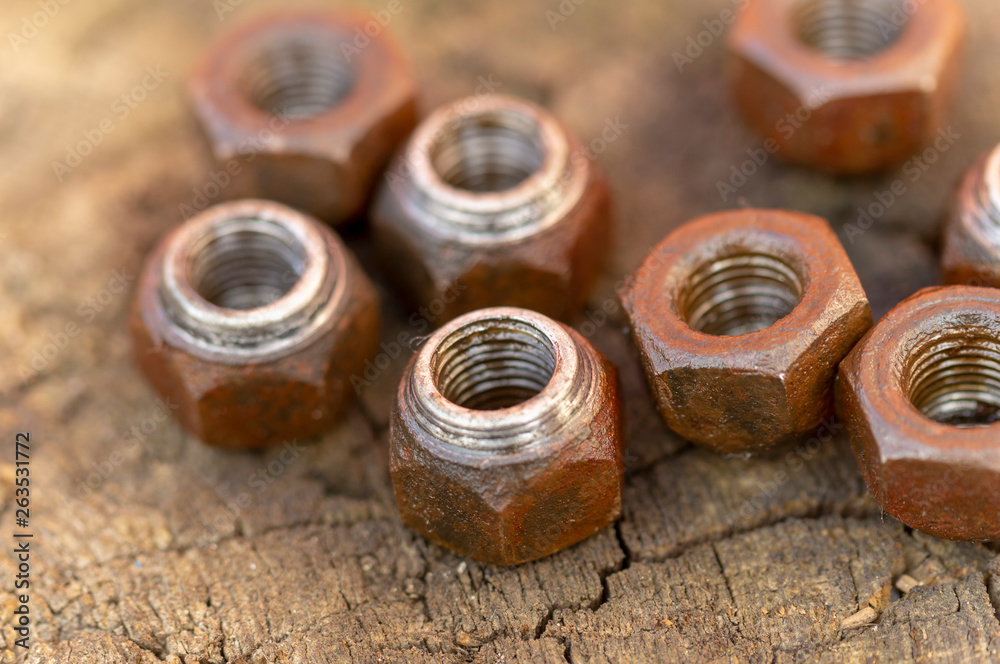 lots of rusty nuts on wooden background