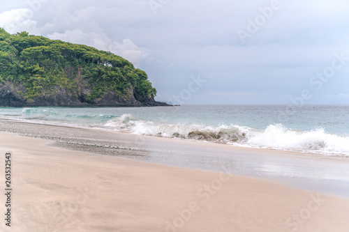Waves breaking on a white sand "Pasir Putih" or "Perasi" beach or virgin beach on Bali, Indonesia
