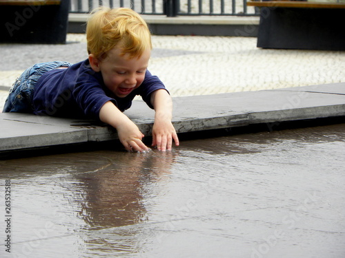 little boy playing with water