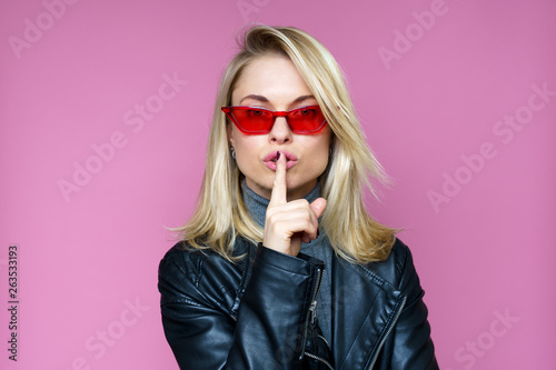 Photo of pensive blonde woman in pink glasses.