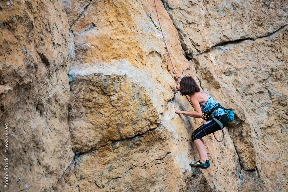 A woman climbs the rock.