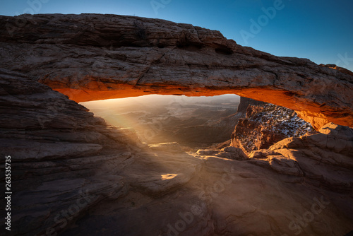Morning sun light shines through mesa arch in Canyonlands National park Utah outside of Moab UT just past arches national park in the desert area near the green river 