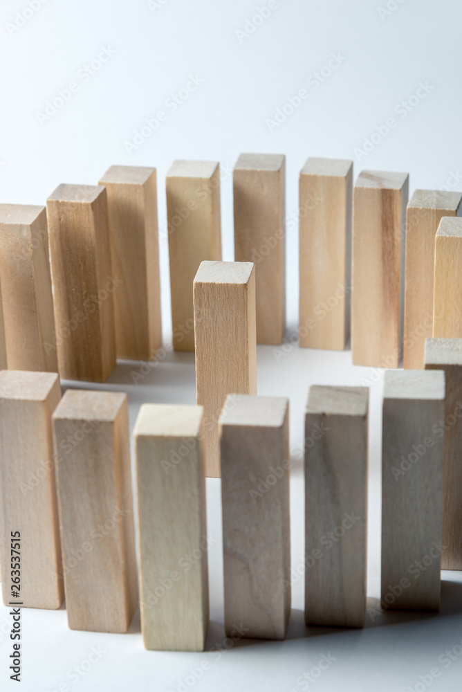 a large circle of wooden cubes, in the center in one, as a symbol of lines, a range of tasks and a leader, on an uneven white background. Vertical frame a large circle of wooden cubes, in the center in one, as a symbol of lines, a range of tasks and a leader, on an uneven white background. Vertical frame