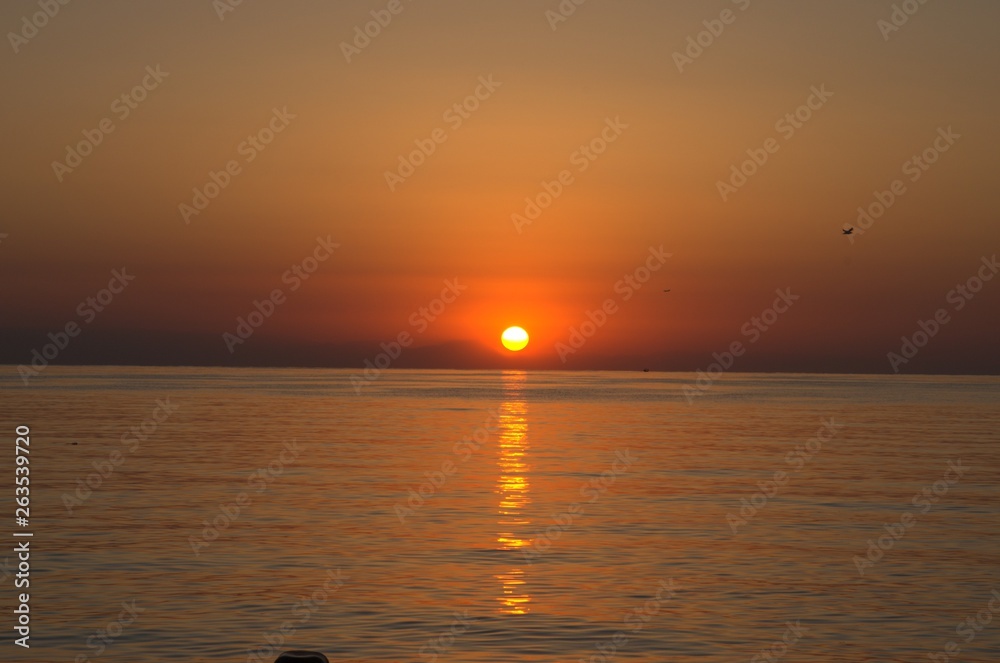 Sunset with large yellow sun under the sea surface Sunset with large yellow sun under the sea surface