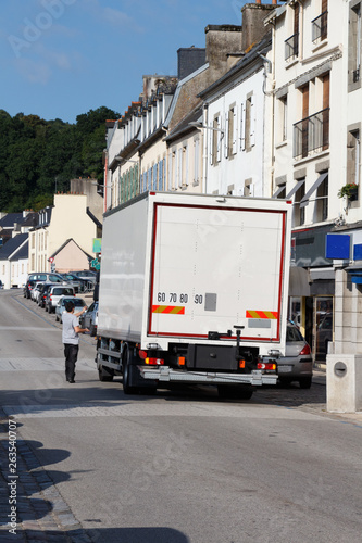 Truck parks in a street to deliver goods in a shop in Chateaulin