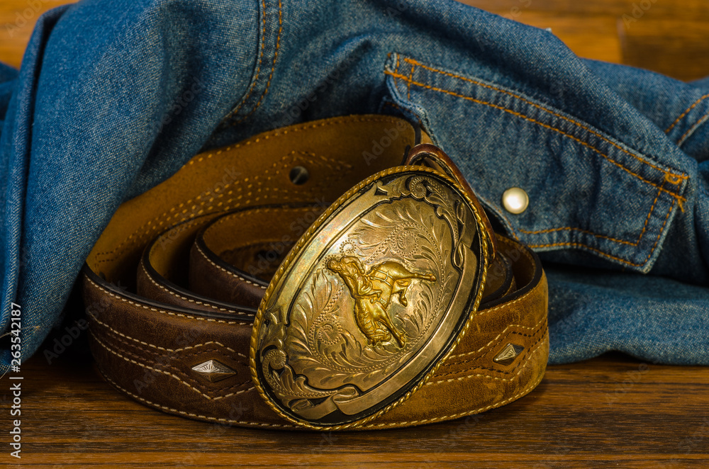 voorzien Ieder overeenkomst Vintage Western Belt Buckle on Rustic Wood with Denim Shirt Stock Photo |  Adobe Stock