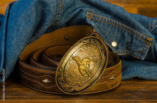 Vintage Western Belt Buckle on Rustic Wood with Denim Shirt