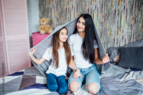 Two pretty sisters with covert on head siting on bed! © Тарас Нагирняк