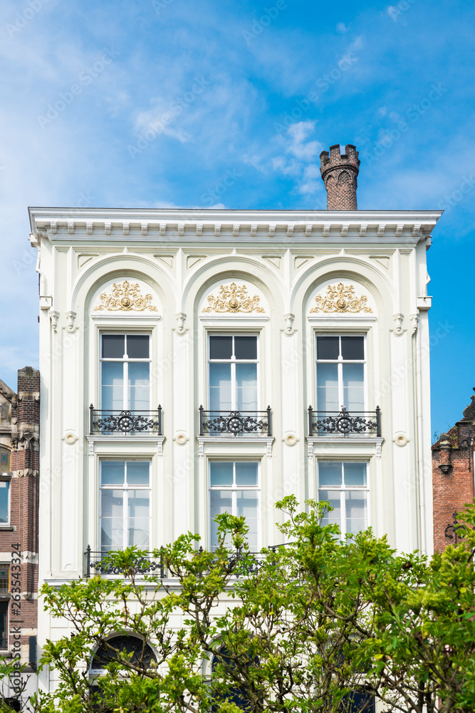 white decorative historical building in Utrecht, The Netherlands, against blue  sky