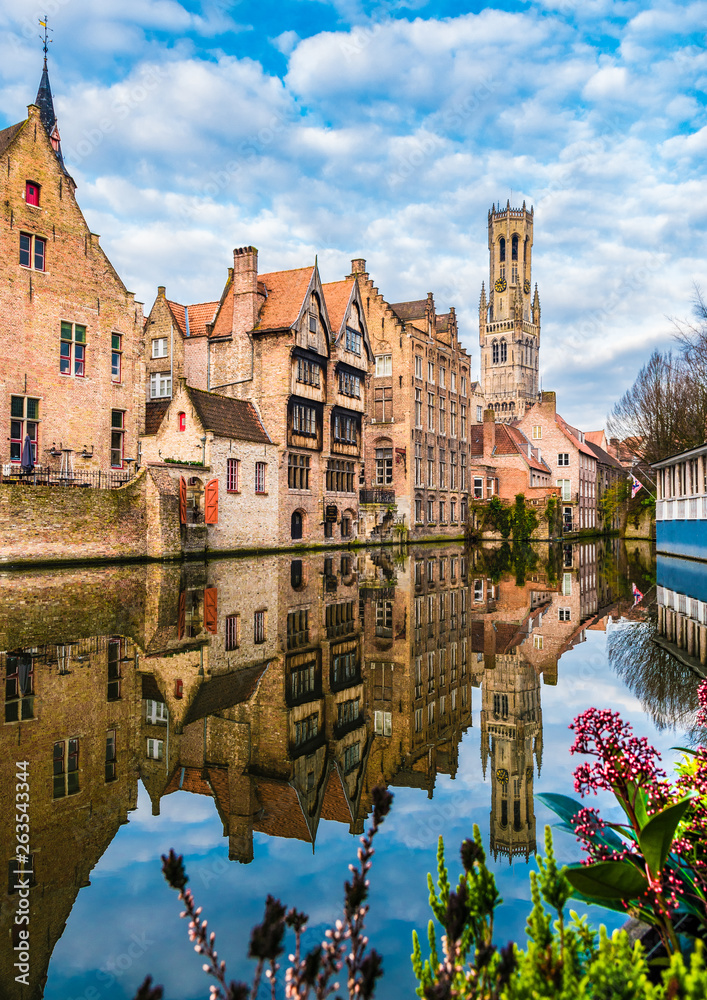 Fototapeta premium Landscape with famous Belfry tower and medieval buildings along a canal in Bruges, Belgium