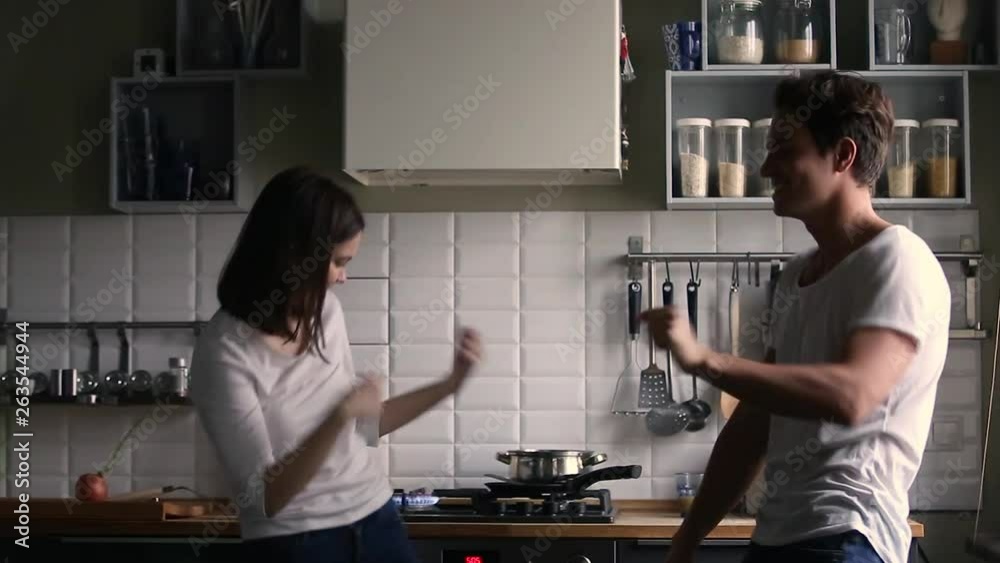 Happy teen couple dancing having fun in the kitchen Happy teen couple dancing having fun in the kitchen