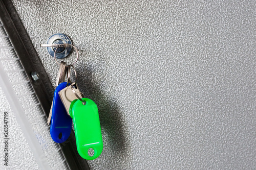 bundle of keys at keyhole of fend lock on a metal textured background.  forgoten key concept. security concept.