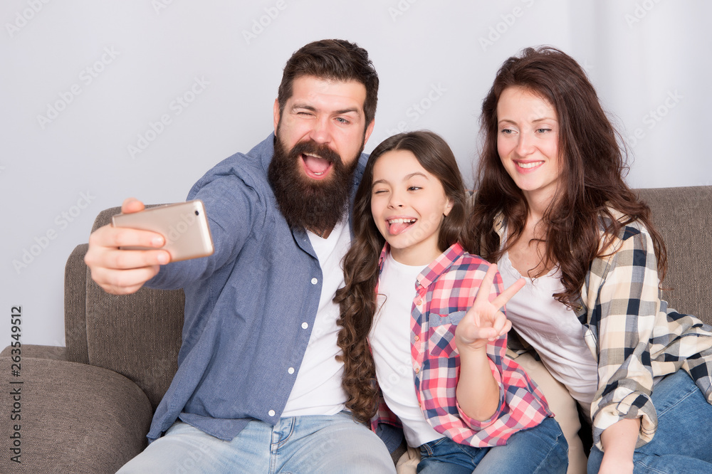 Selfie. Happy family at home. Modern smartphone. Little girl use smartphone with mother and father. bearded man and woman with daughter. Selfie mania. Family make selfie on smartphone. Capturing fun Selfie. Happy family at home. Modern smartphone. Little girl use smartphone with mother and father. bearded man and woman with daughter. Selfie mania. Family make selfie on smartphone. Capturing fun