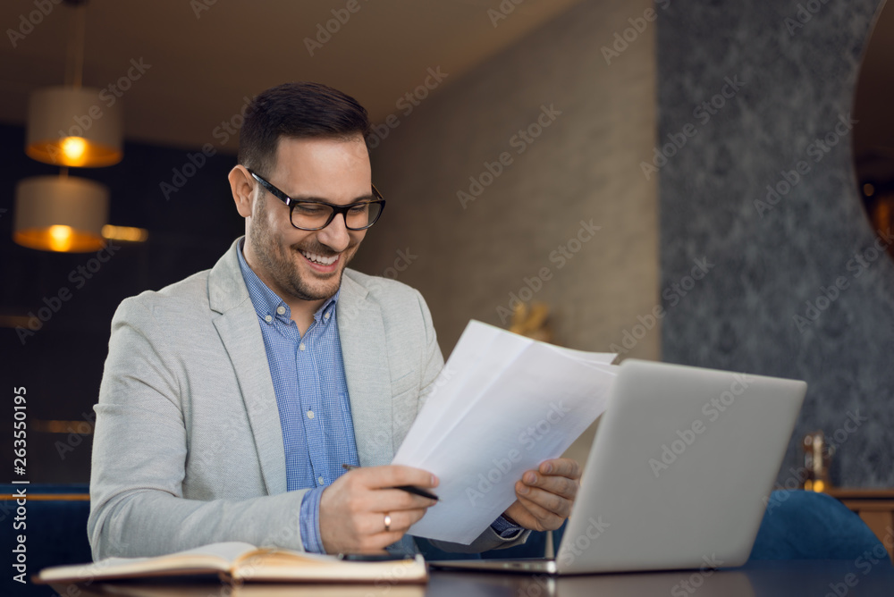 Happy businessman working on reports in the office Happy businessman working on reports in the office