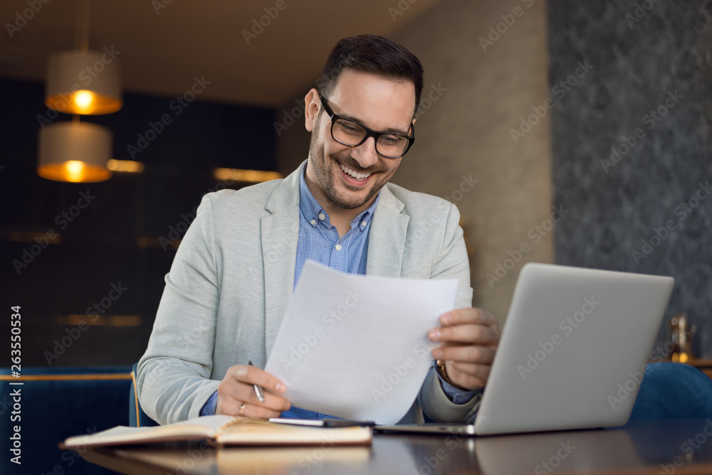 Happy businessman working on reports in the office Happy businessman working on reports in the office