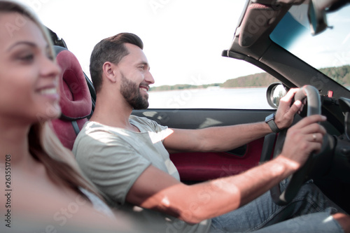 close up.smiling couple sitting in a convertible car