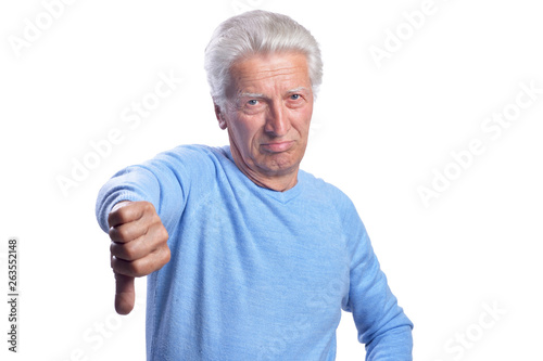 Senior man showing thumbs down on white background
