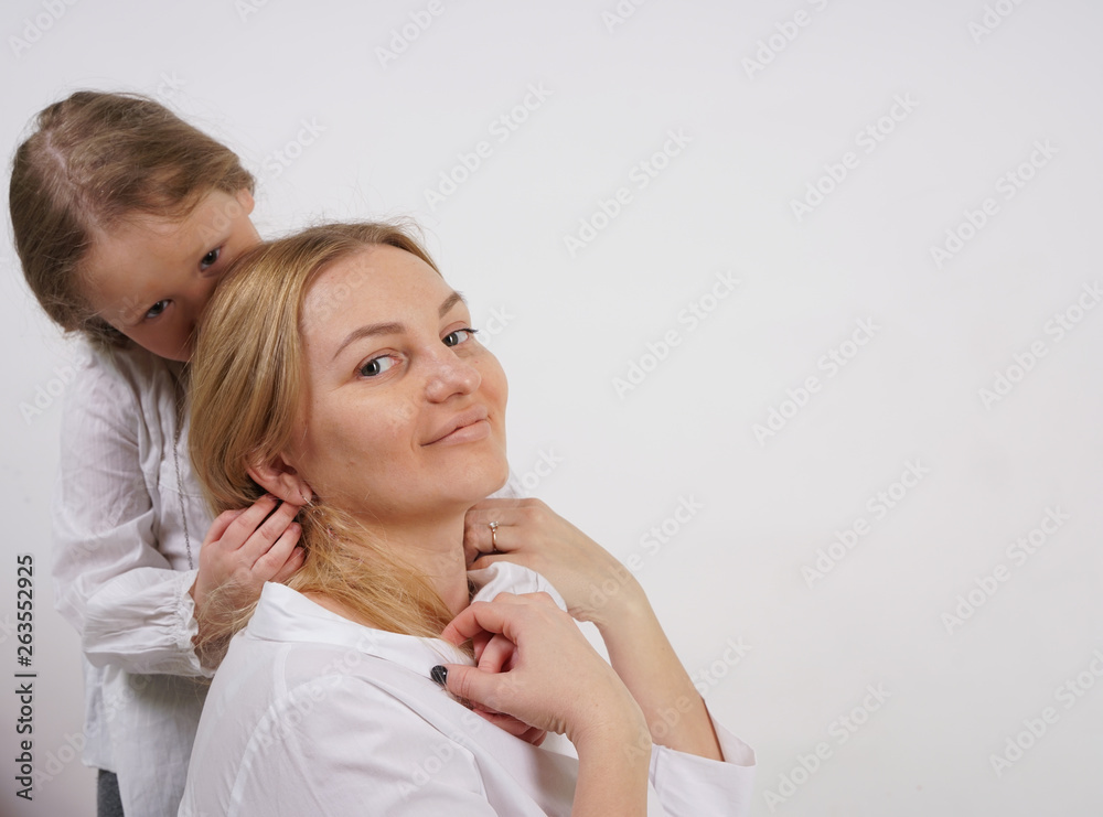 real family of caucasian mother and daughter in white shirts in the studio background real family of caucasian mother and daughter in white shirts in the studio background