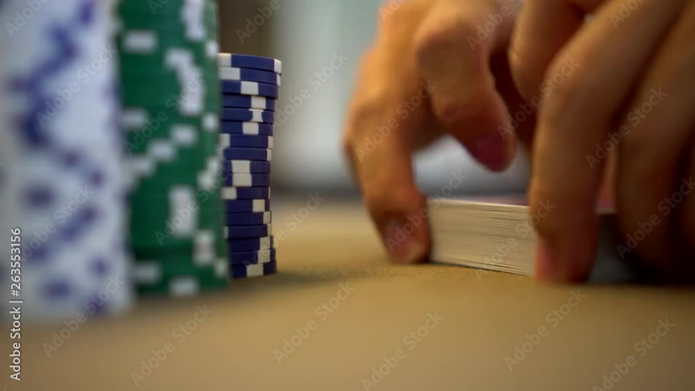 fancy shuffling of playing cards at a poker table casino in vegas with poker chips fancy shuffling of playing cards at a poker table casino in vegas with poker chips