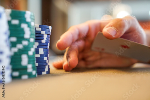 secretly palming a playing card at the poker table with poker chips at a vegas casino