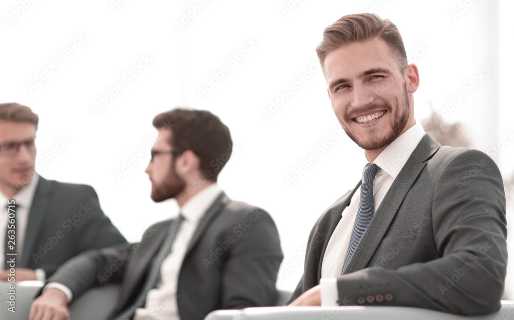 smiling businessman in the background of the office. smiling businessman in the background of the office.