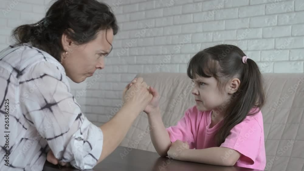 Competition on the hands. A mother and daughter are trying to measure a steel on their hands. Competition on the hands. A mother and daughter are trying to measure a steel on their hands.