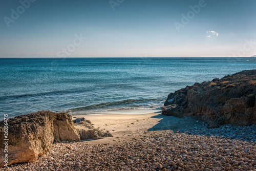 Crystal clear sea with rocks on a pebble beach