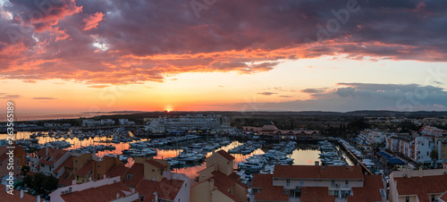 Aerial panoramic view of the Vilamoura marina in Portugal as the sunsets in the distance on a dramatic cloudy day. photo