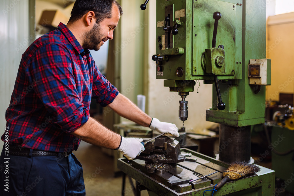 Worker using metal file in a factory Worker using metal file in a factory