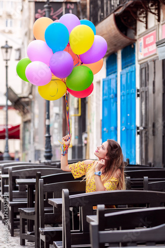 A girl smiles with ballons in hand