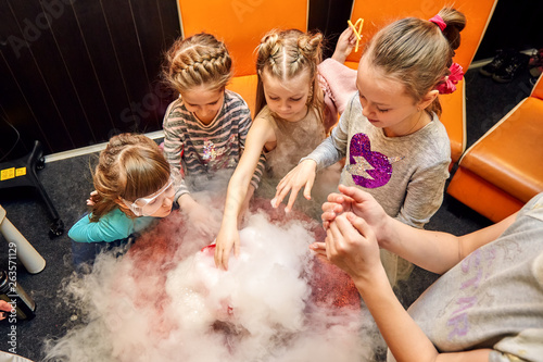 Chemical show for kids. Professor carried out chemical experiments with liquid nitrogen on Birthday little girl. photo