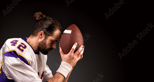 american football player with a ball On moment to pray before the game