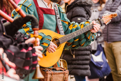 Medieval troubadour playing an antique guitar. photo