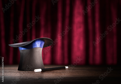 high contrast image of magician hat and wand on stage photo