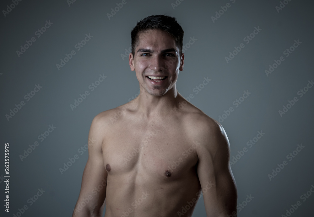 Fototapeta premium Portrait of strong handsome Athletic man feeling good and happy isolated on neutral background