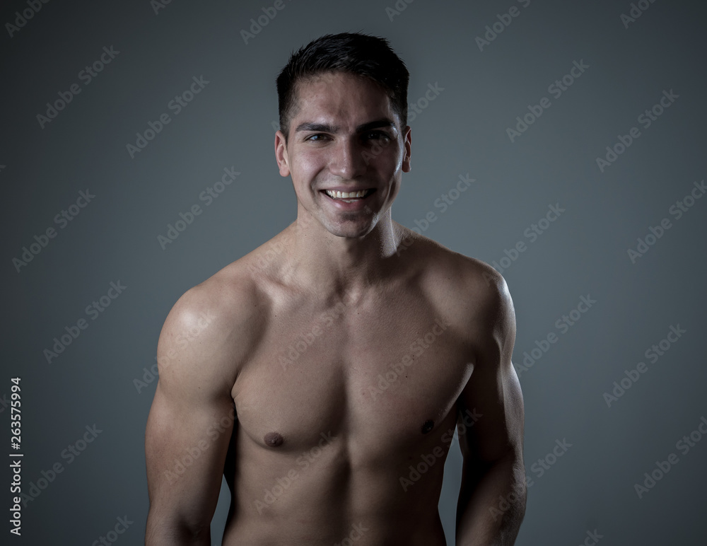 Fototapeta premium Portrait of strong handsome Athletic man feeling good and happy isolated on neutral background