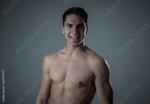 Portrait of strong handsome Athletic man feeling good and happy isolated on neutral background