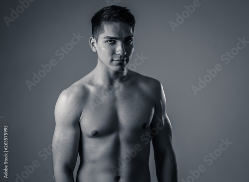 Portrait of strong healthy handsome Athletic man isolated on neutral background © SB Arts Media