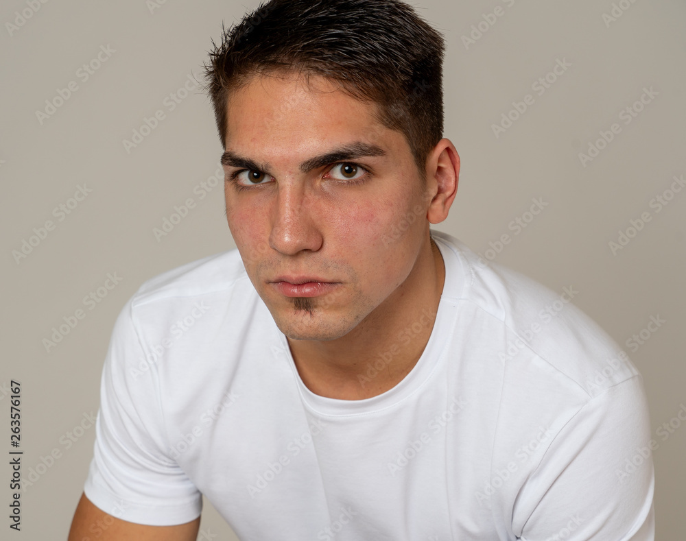 Natural portrait of young attractive man in his 20s looking and posing with neutral face expression Natural portrait of young attractive man in his 20s looking and posing with neutral face expression