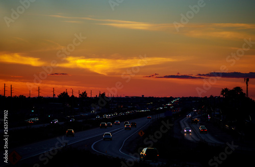 Sunset over city cars on highway road on sunset evening night in urban view
