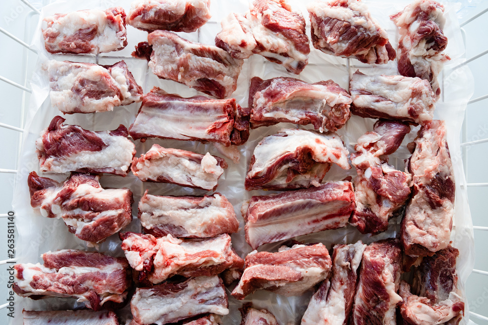 Raw pork ribs chopped in pieces on the white table high angle view